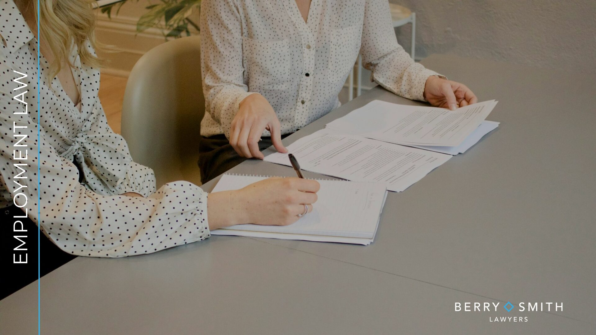 Two people reviewing employment documents during a workplace advice meeting.