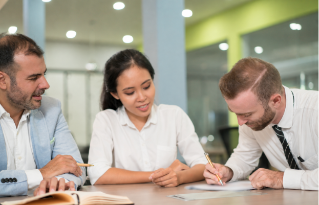 Professional signing documents during an office meeting.